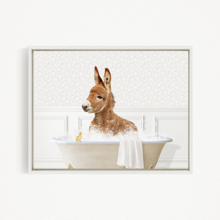 A brown donkey is sitting in a bathtub filled with bubbles, with a yellow duck nearby.