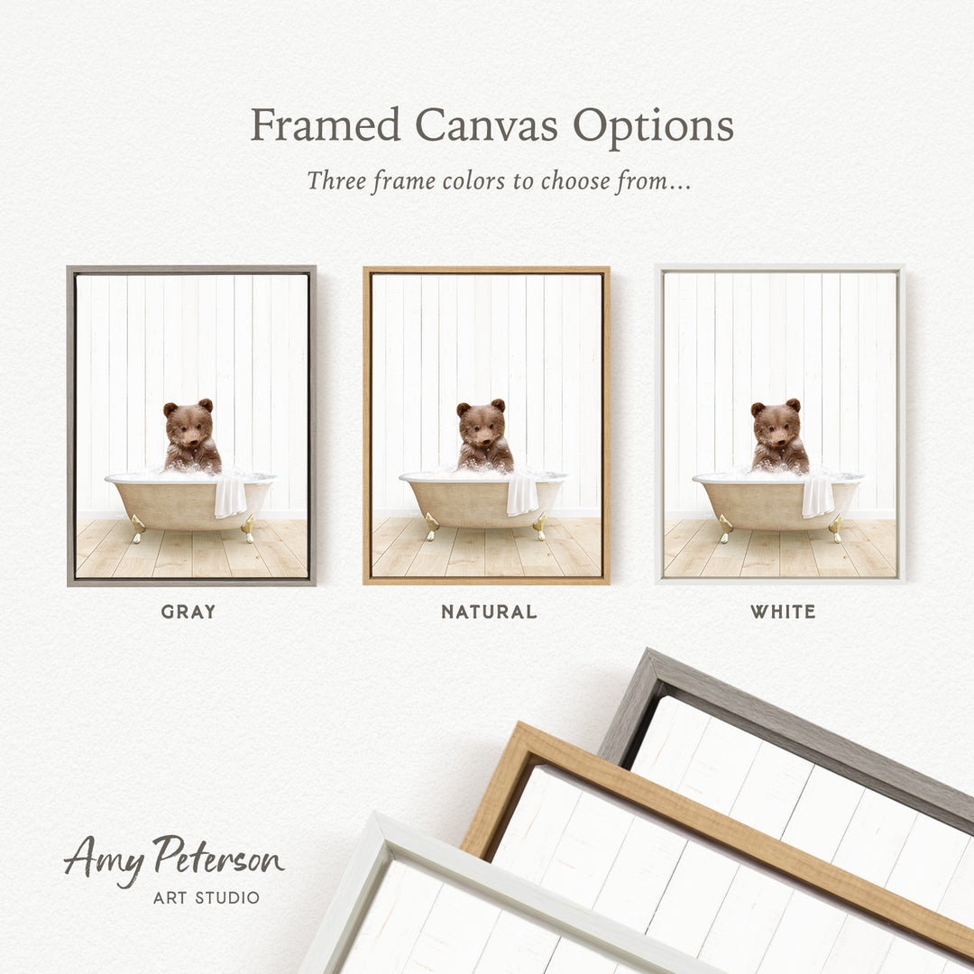 The image is a framed canvas option showcasing three different frame colors: gray, natural, and white. The canvas features a small brown bear sitting in a bathtub, and the frame color options are displayed below the canvas.