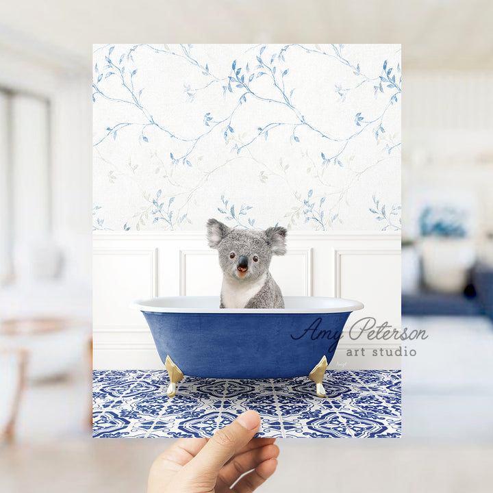 a hand holding a card with a picture of a koala in a bathtub