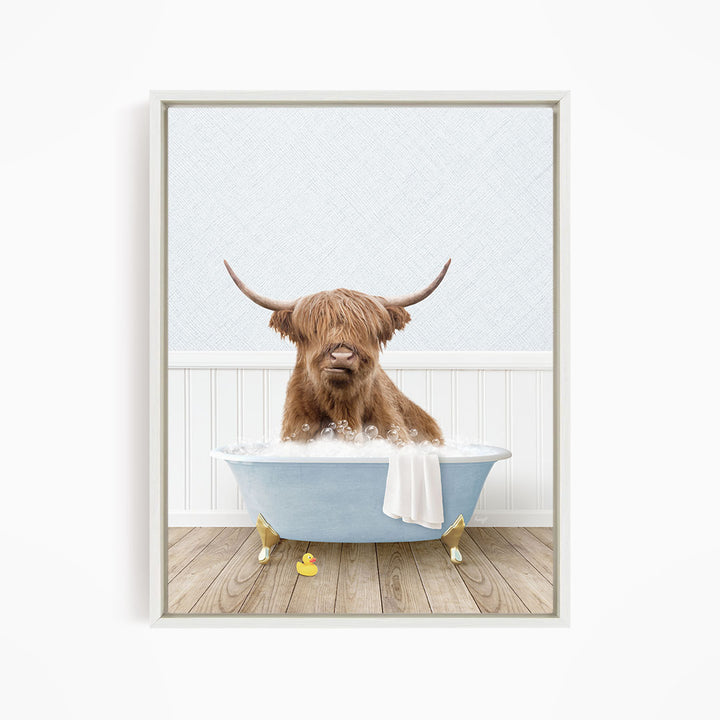 A brown cow with long horns is sitting in a blue bathtub filled with water, surrounded by rubber ducks.