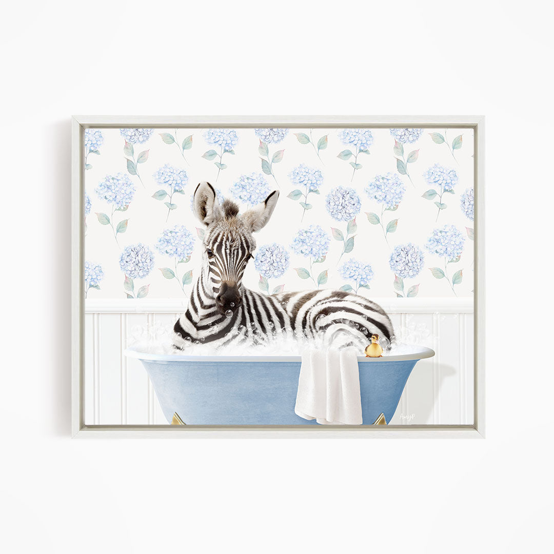 A zebra is sitting in a blue bathtub, surrounded by a floral patterned wall.