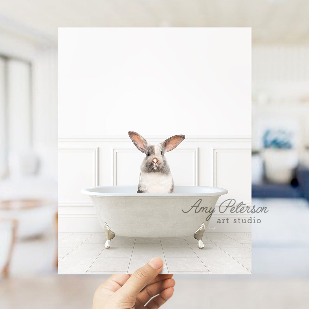 a person holding up a card with a picture of a bunny in a bathtub