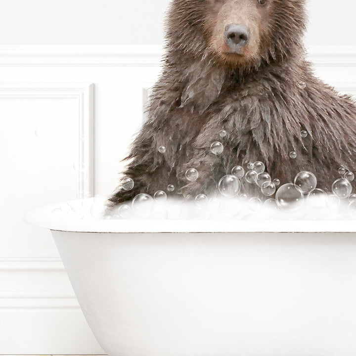 a brown bear sitting in a bathtub filled with bubbles