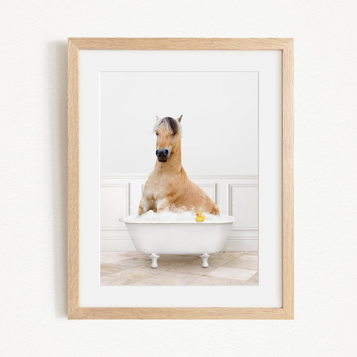 A brown horse sitting in a white bathtub filled with water, with a yellow rubber duck floating in the water.
