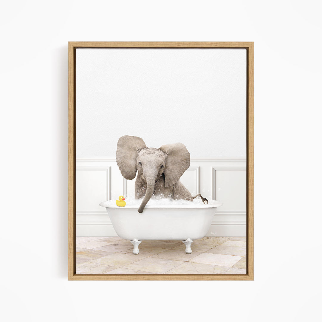 A baby elephant sitting in a white bathtub, with a yellow rubber duck floating on the water.