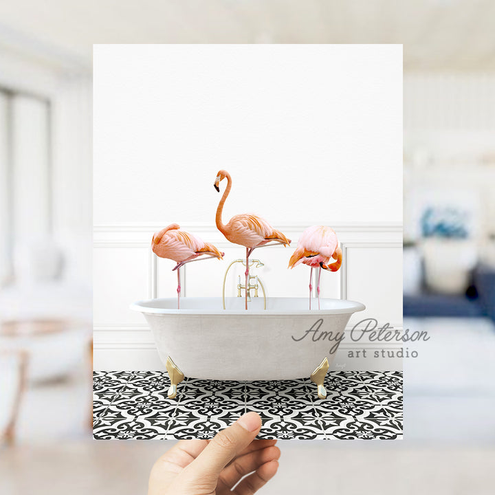 a person holding a card with flamingos in a bathtub