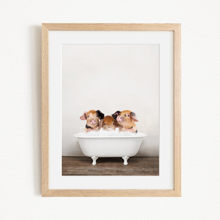 Three adorable brown and white pigs sitting in a white bathtub, enjoying a relaxing bath.