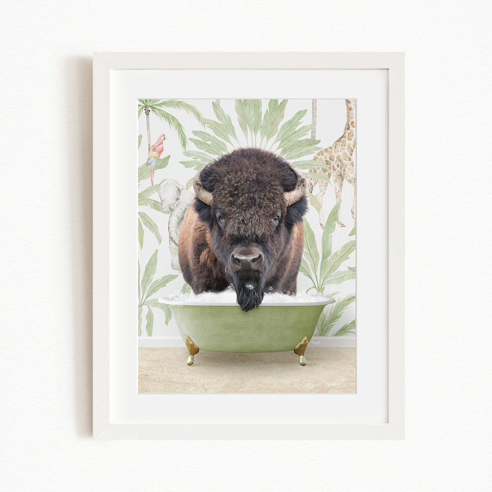 A framed image depicting a bison standing in a green bathtub, surrounded by tropical foliage and a giraffe.