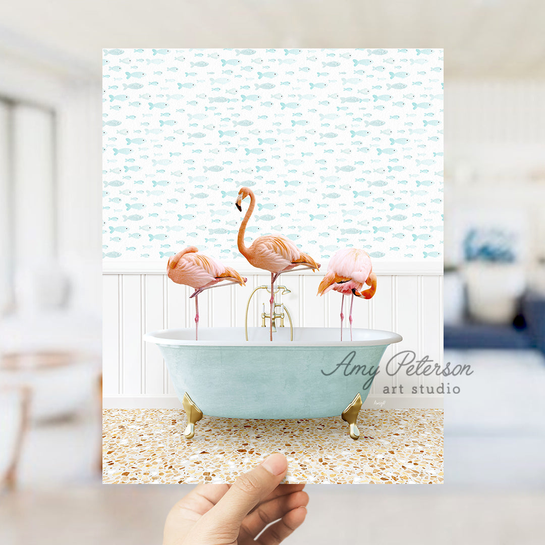 a person holding up a card with three flamingos in a bathtub