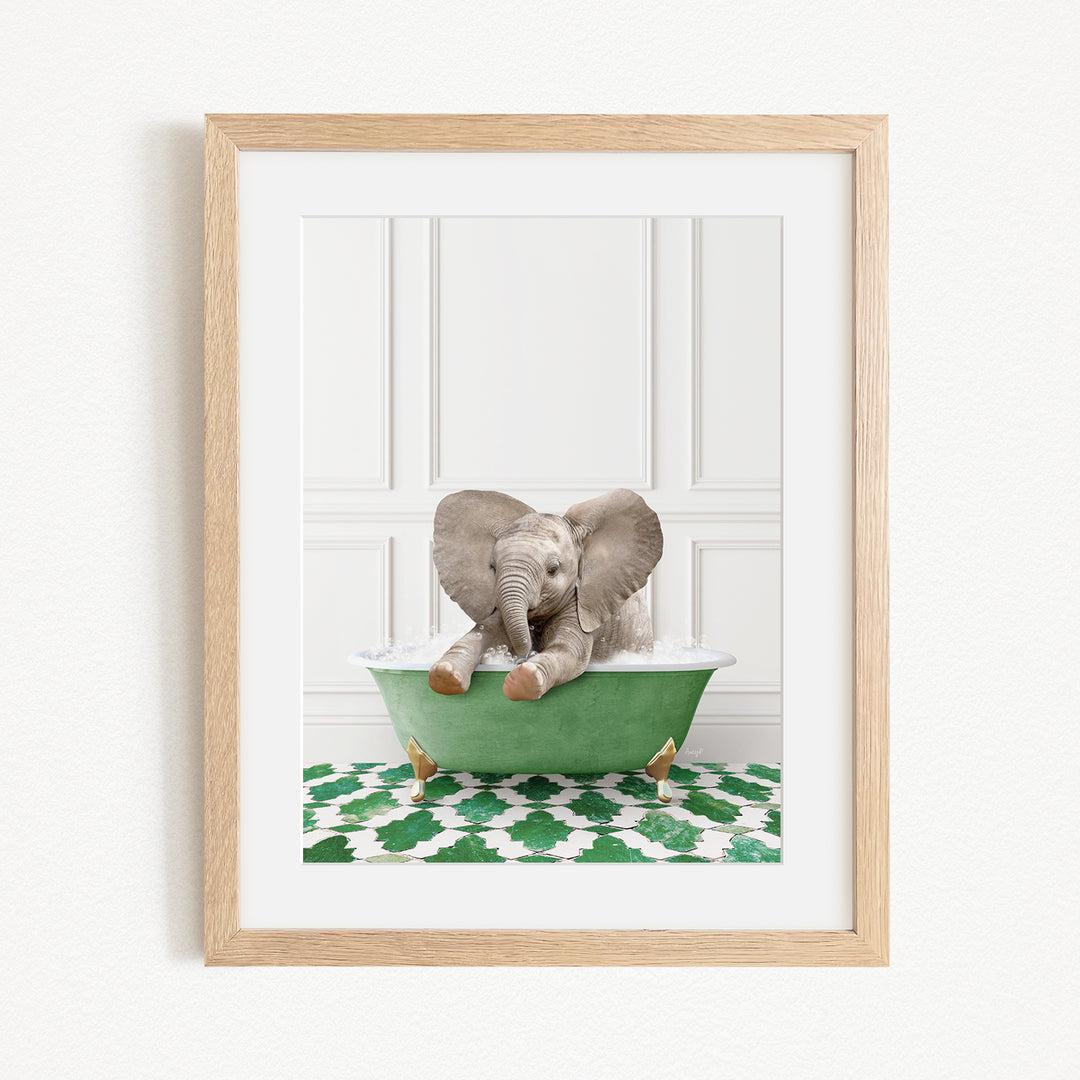 A baby elephant sitting in a green bathtub filled with water, surrounded by a patterned green and white rug.