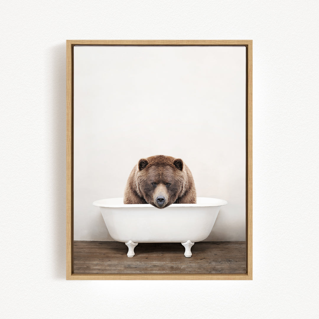 A brown bear is sitting in a white bathtub, appearing relaxed and content.