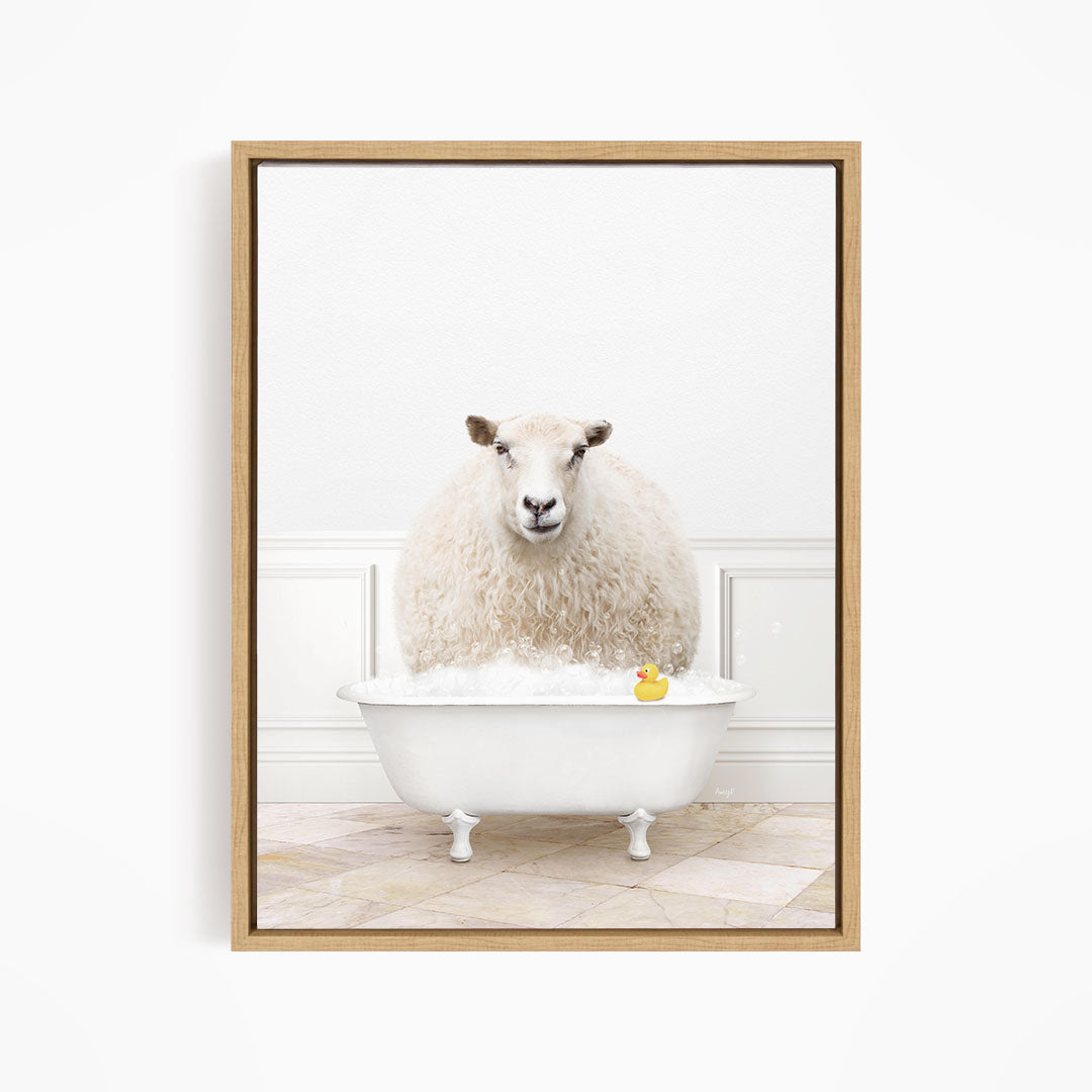 A fluffy white sheep sits in a white bathtub filled with bubbles, with a yellow rubber duck floating in the water.