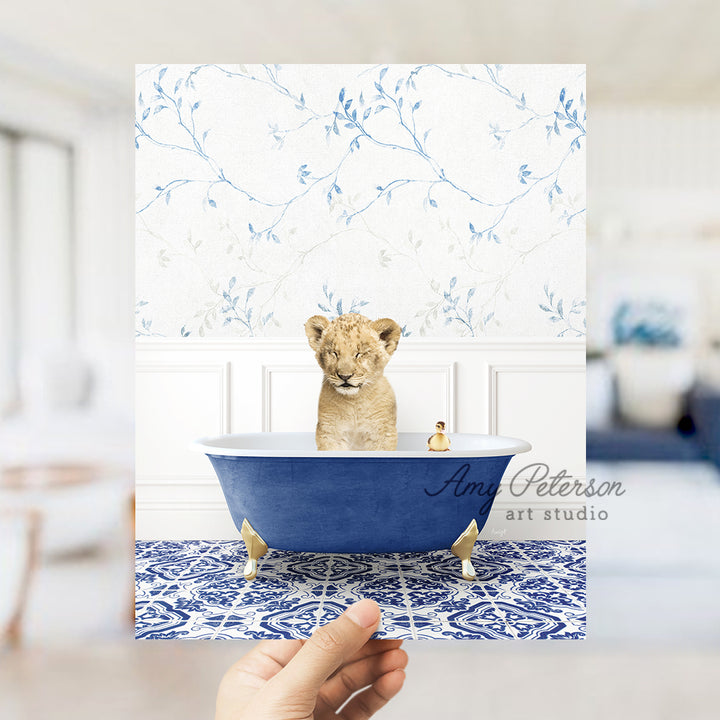 a hand holding a card with a picture of a baby lion in a bathtub