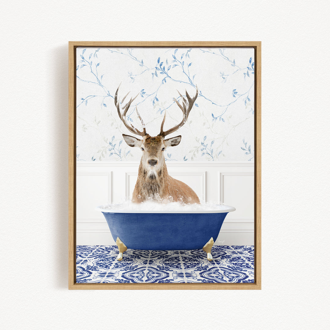 A deer with large antlers is sitting in a blue bathtub, surrounded by a patterned tile floor and a floral wallpaper background.