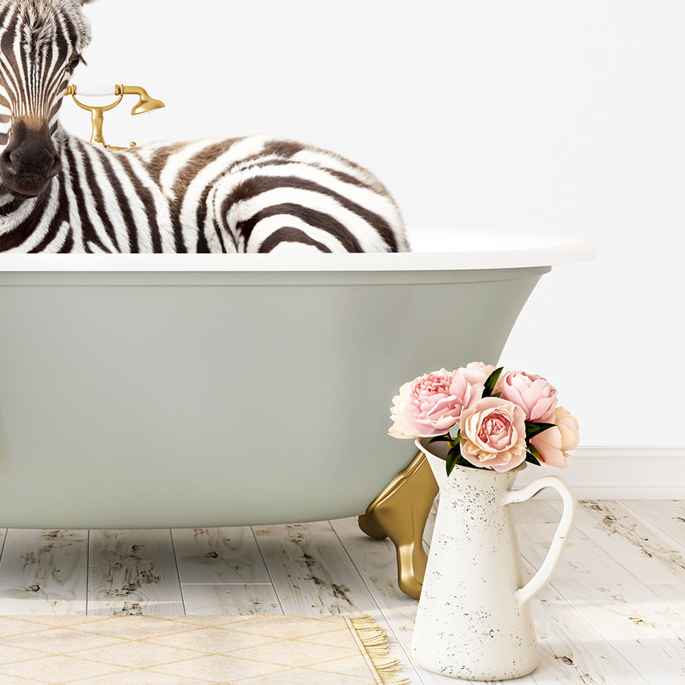 A zebra is sitting in a green bathtub, with a vase of pink flowers next to it on a white floor.