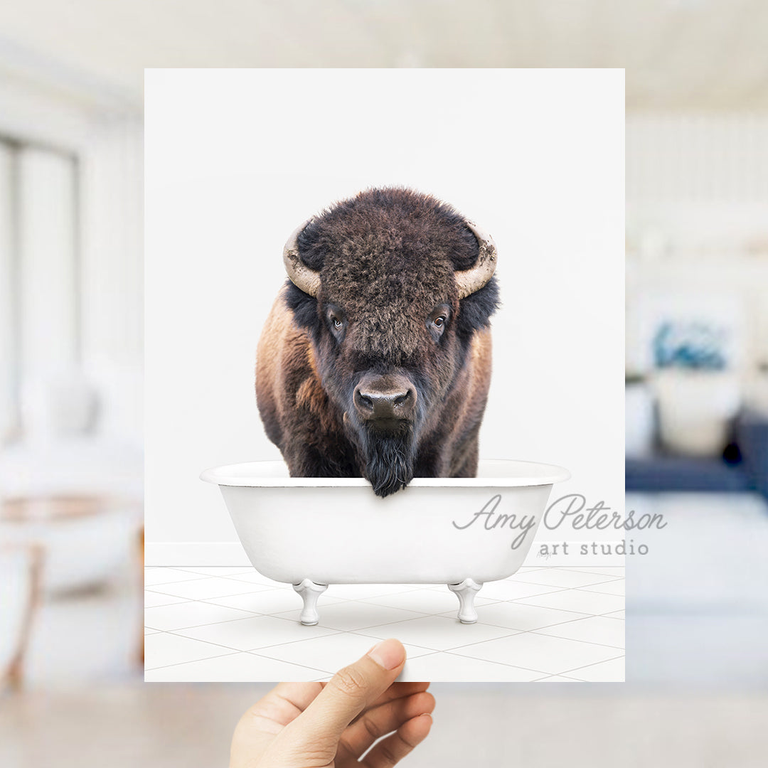 a person holding up a card with a picture of a bison in a bathtub