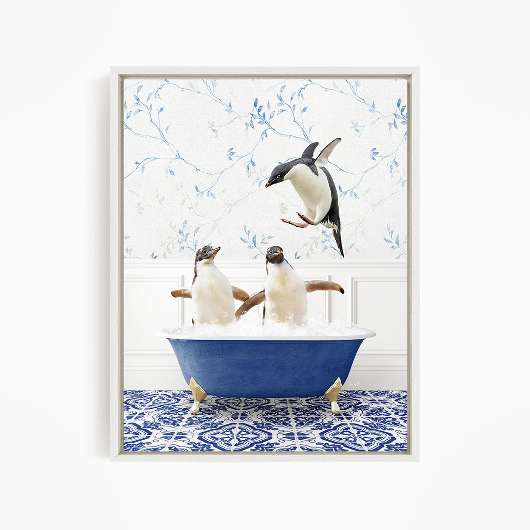 A framed image depicting two penguins sitting in a blue bathtub, with one penguin flying towards the other in mid-air.
