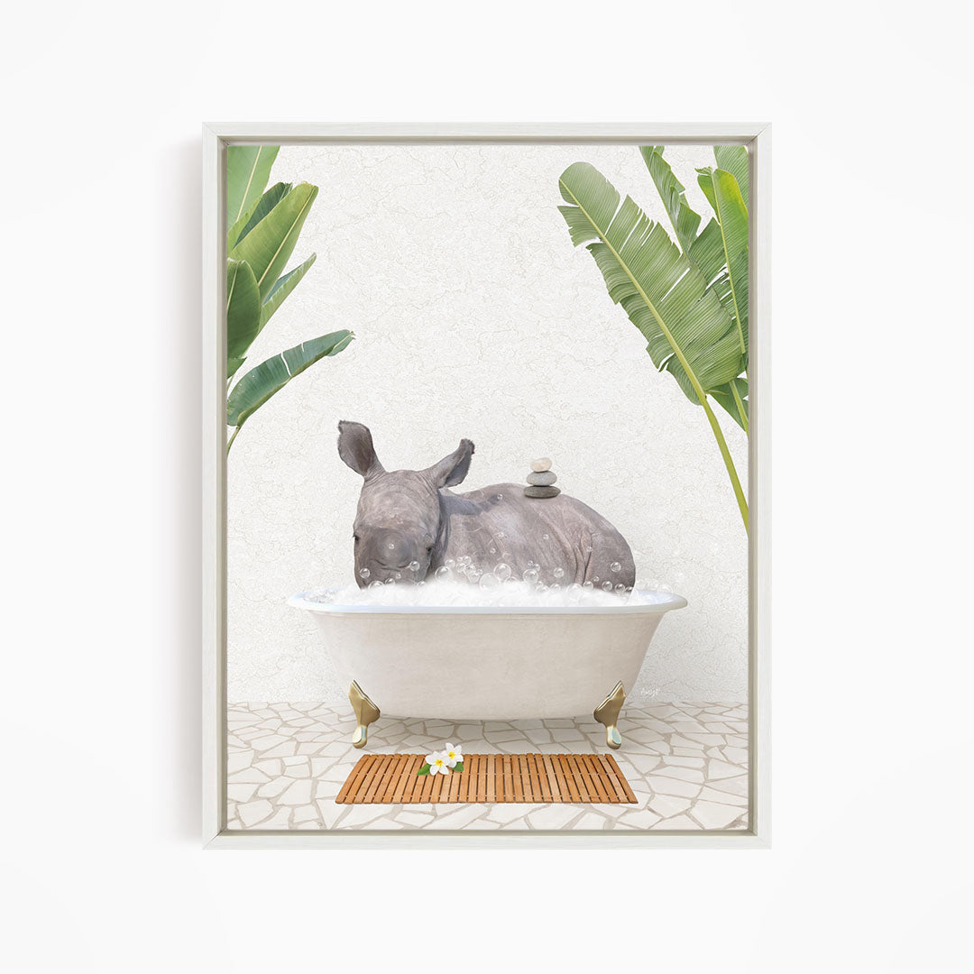 A rhinoceros is sitting in a bathtub filled with water, surrounded by tropical plants and a wooden mat on the floor.