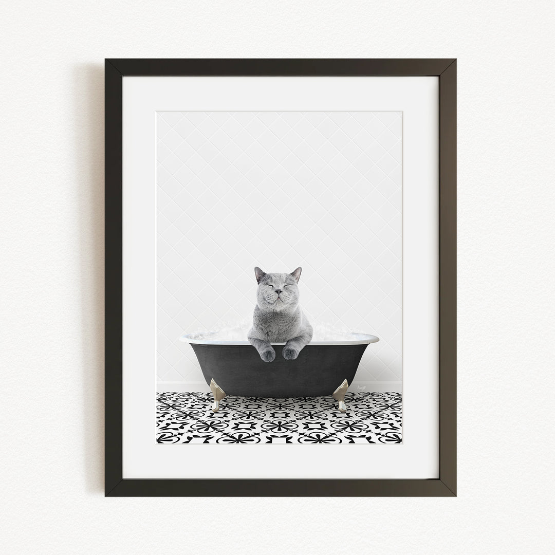 A gray cat sitting in a black bathtub, with a patterned tile floor in the foreground.