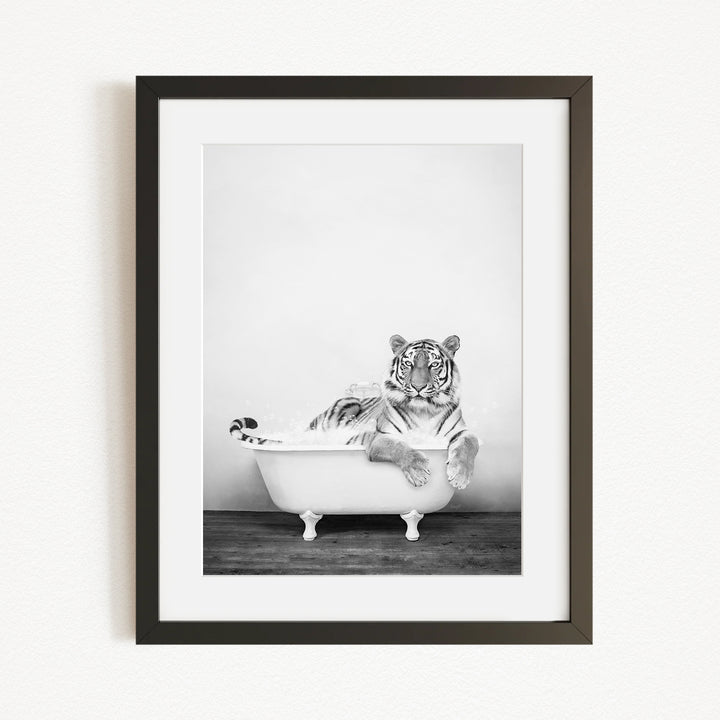A tiger is sitting in a bathtub, appearing relaxed and enjoying the bath.