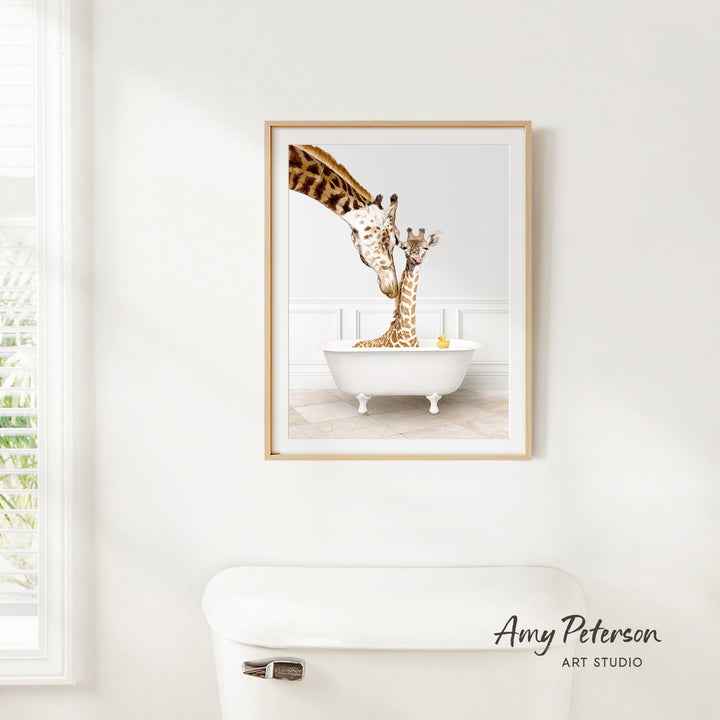 A framed image of two giraffes sitting in a white bathtub, with one giraffe reaching up to the other.