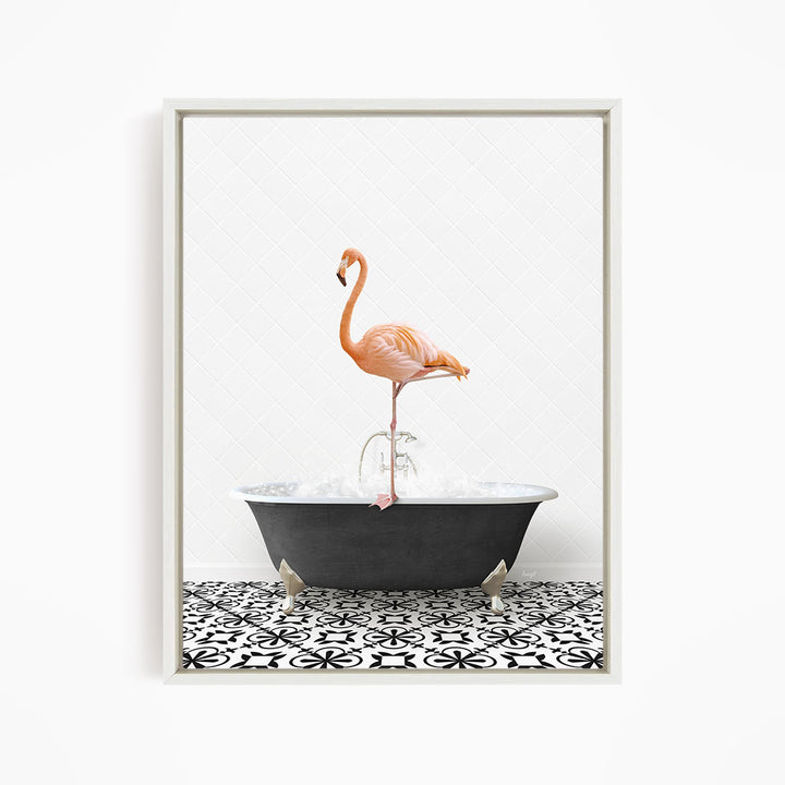 A pink flamingo standing on one leg in a black bathtub filled with water, set against a white tiled wall.