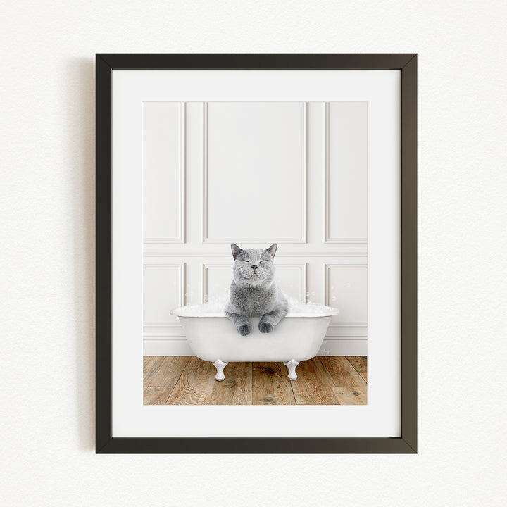 A gray cat sitting in a white bathtub, with a wooden floor in the background.