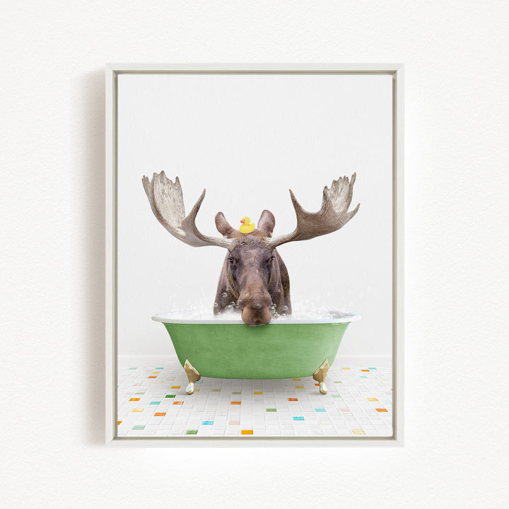 A moose with large antlers is sitting in a green bathtub, with a rubber duck perched on its head.