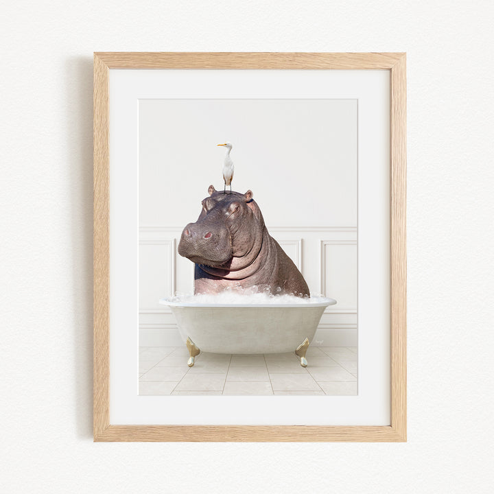 A framed image depicting a large, brown hippopotamus sitting in a bathtub, with a seagull perched on its head.