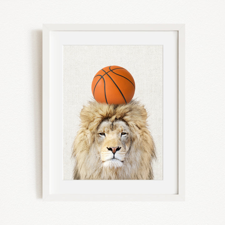 A framed image of a lion with a basketball on its head.