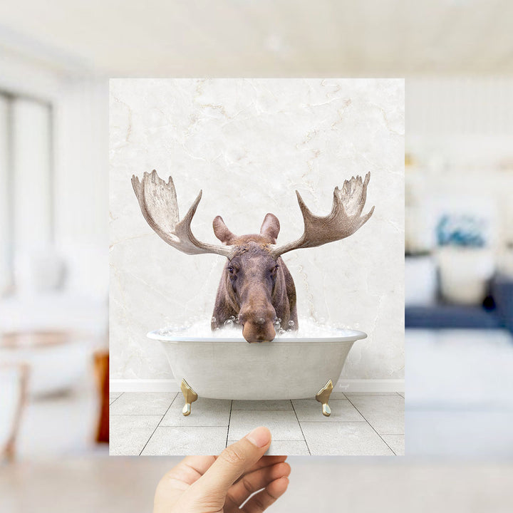A moose with large antlers is sitting in a bathtub filled with water, creating a whimsical and humorous scene.