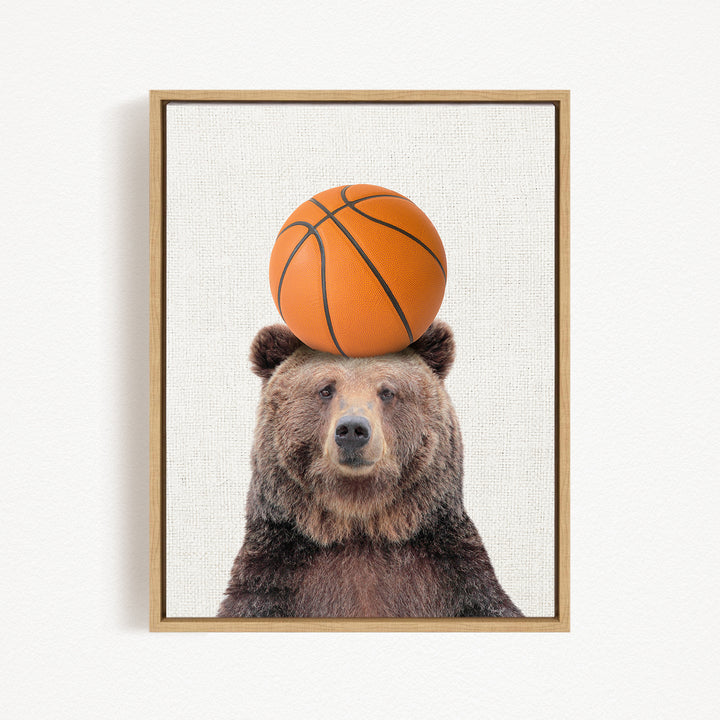 A brown bear balancing a basketball on its head.