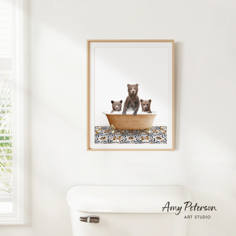 A framed image of three bears sitting in a bathtub, with a patterned tile on the floor.