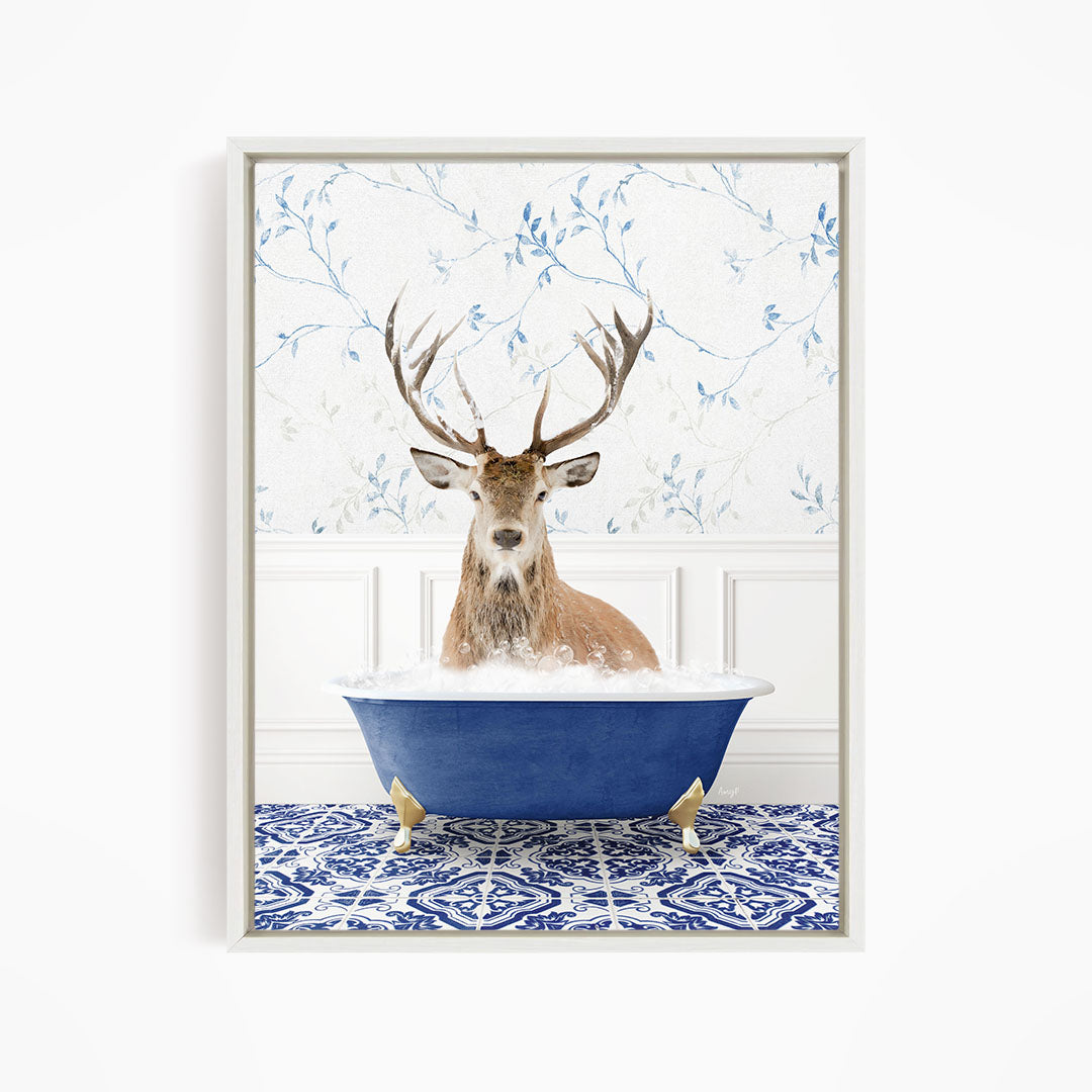 A deer with large antlers is sitting in a blue bathtub filled with water, surrounded by a patterned tile floor.