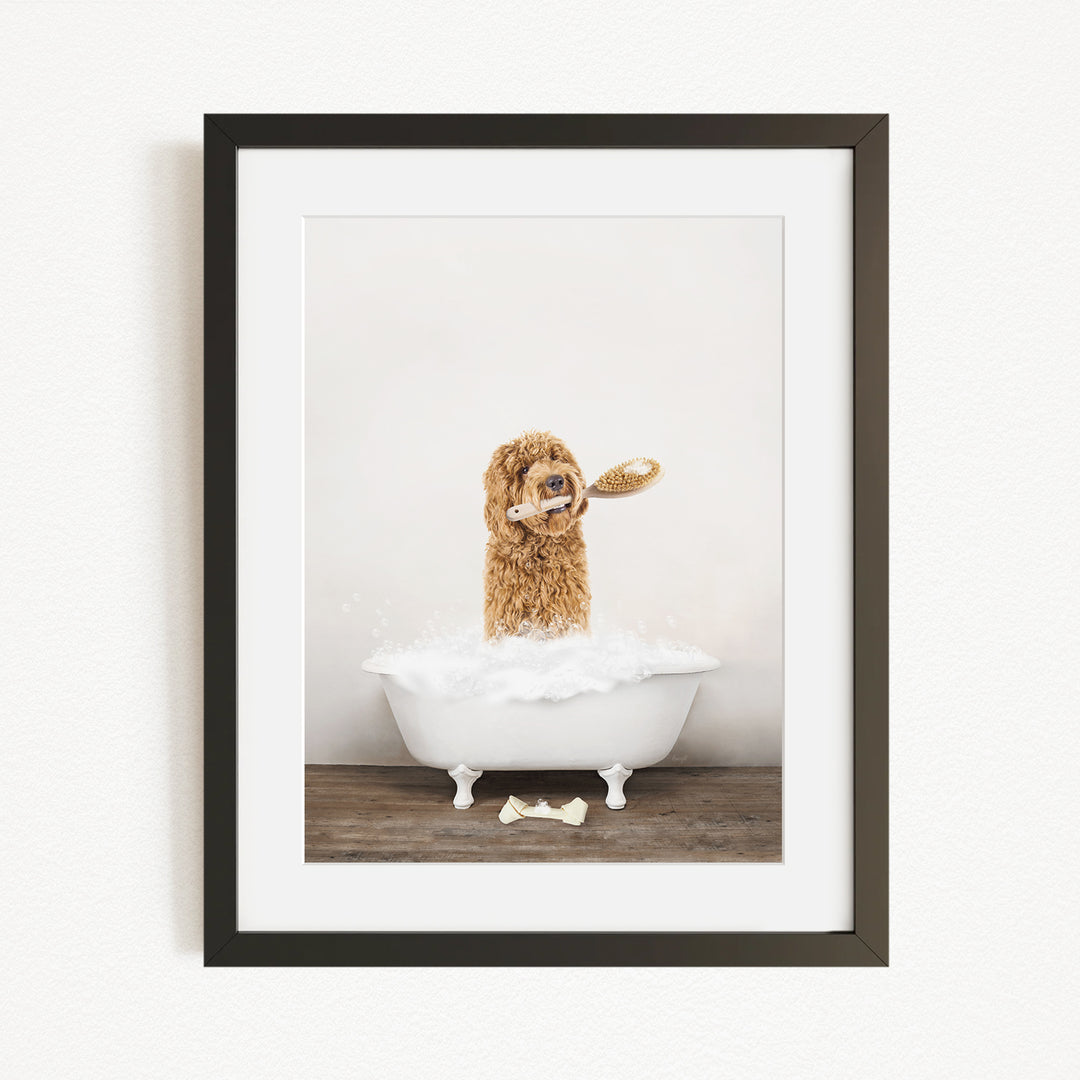 A brown dog is sitting in a white bathtub filled with bubbles, holding a white object in its mouth.