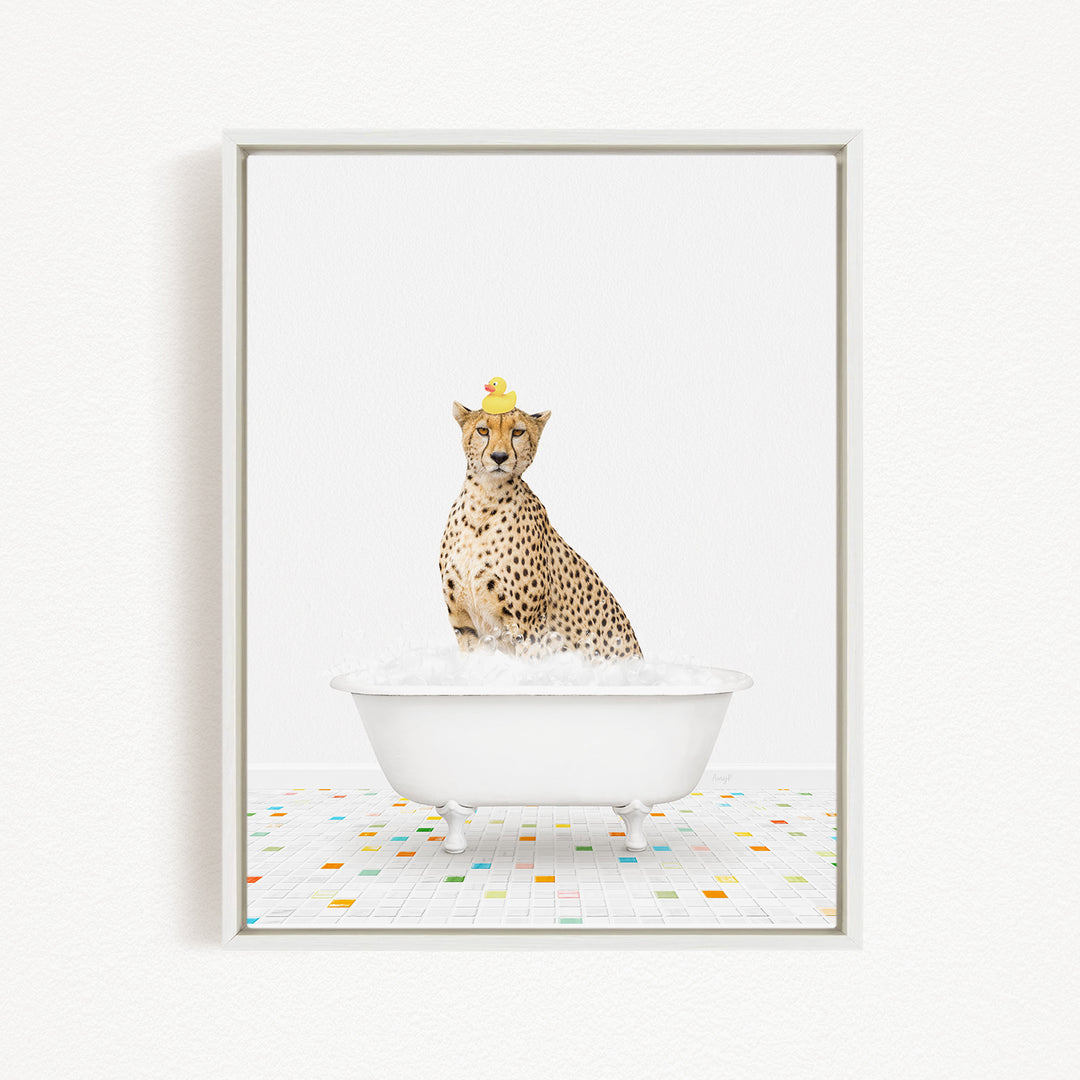 A cheetah sitting in a white bathtub filled with bubbles, with a rubber duck perched on its head.