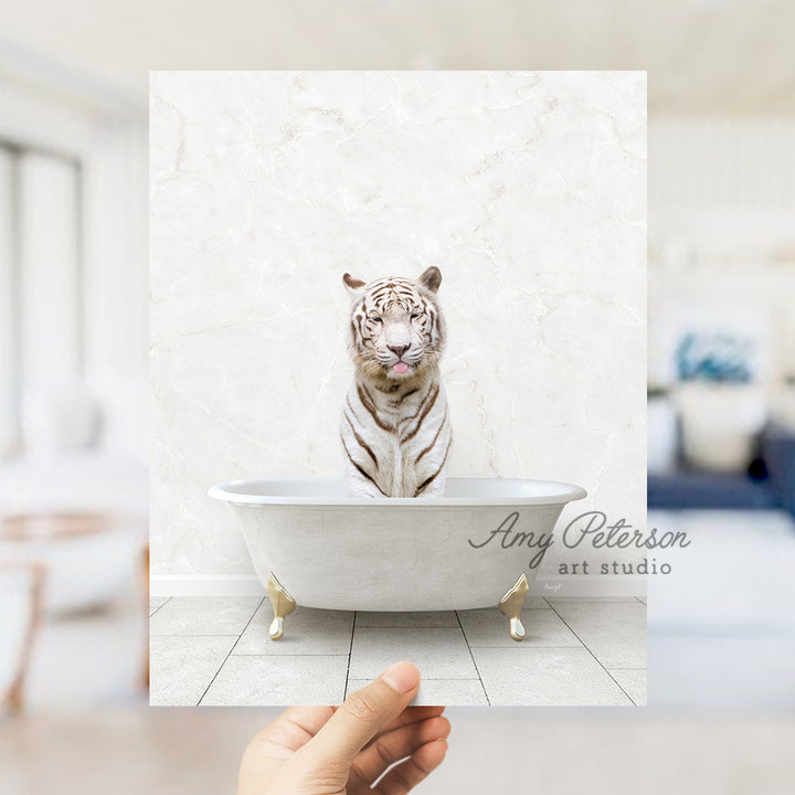 a hand holding up a photo of a tiger in a bathtub