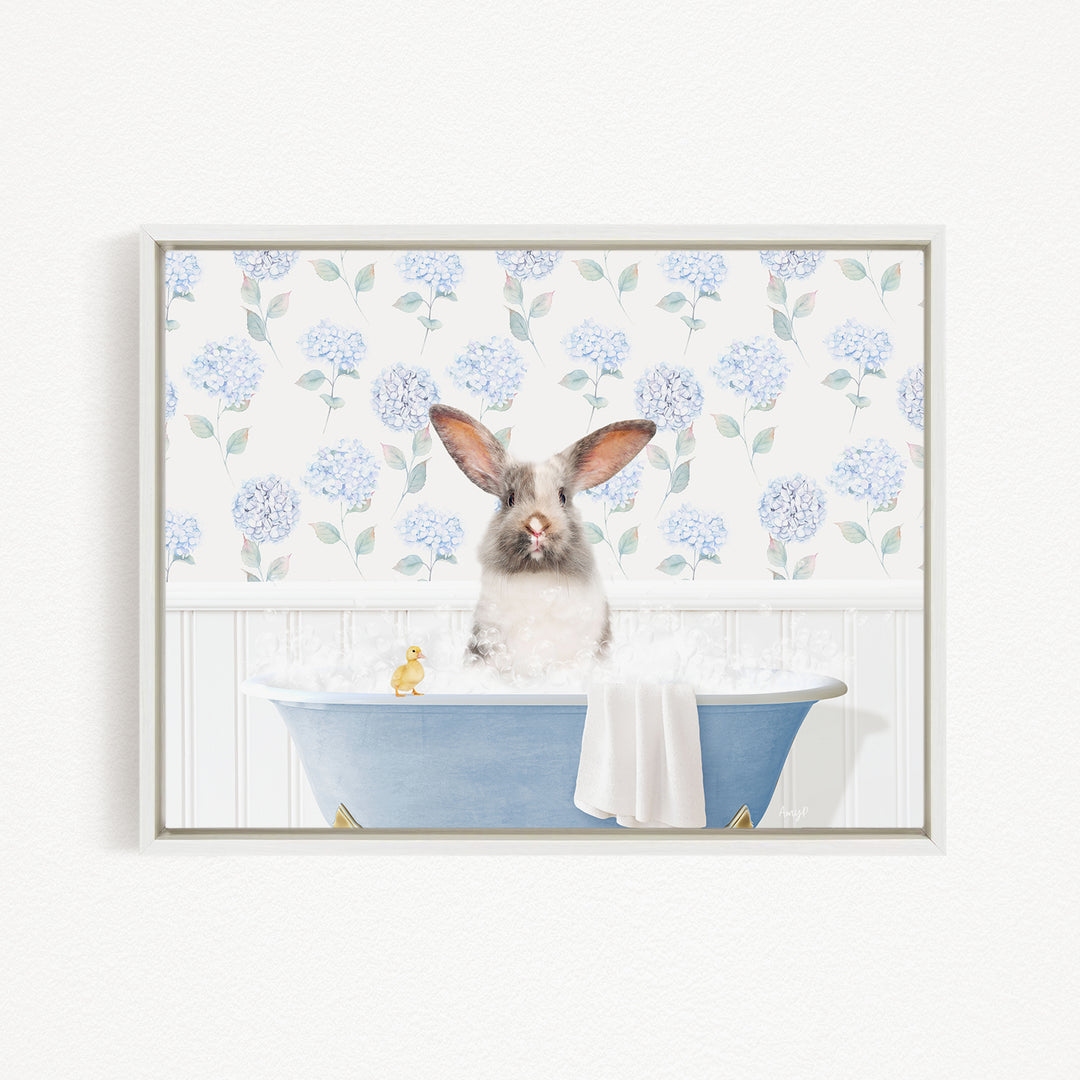 A white rabbit sitting in a blue bathtub filled with bubbles, with a yellow duck floating nearby.