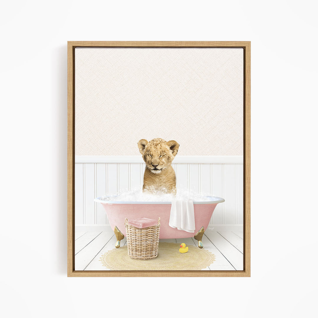 A young lion cub sitting in a pink bathtub filled with bubbles, surrounded by rubber ducks.