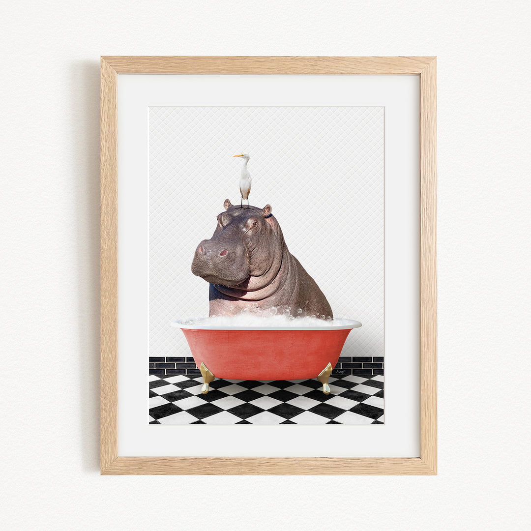 A framed image depicting a large hippopotamus sitting in a red bathtub, with a seagull perched on its head.