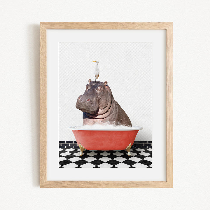 A framed image depicting a large hippopotamus sitting in a red bathtub, with a seagull perched on its head.