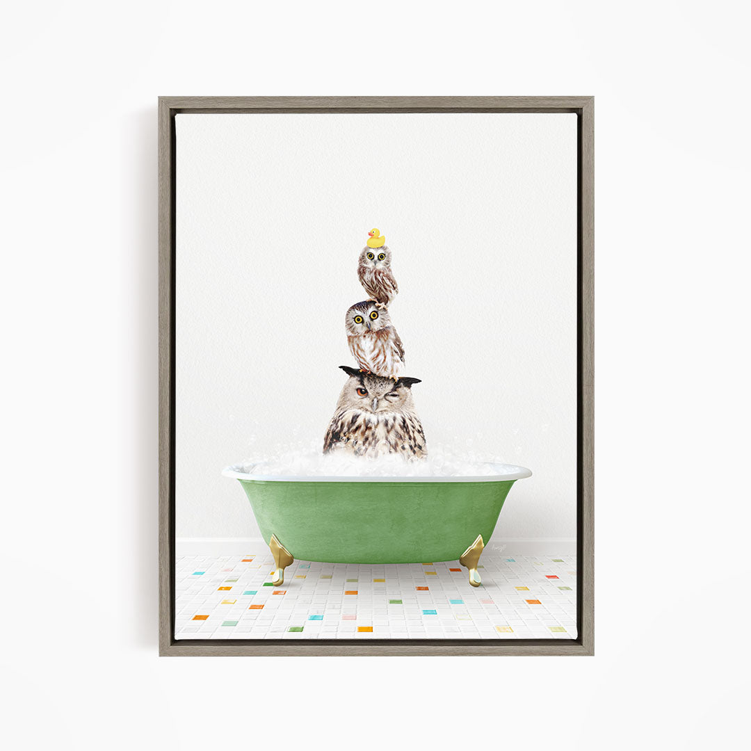 A framed image depicting three owls sitting in a green bathtub filled with bubbles, with one of the owls wearing a yellow hat.