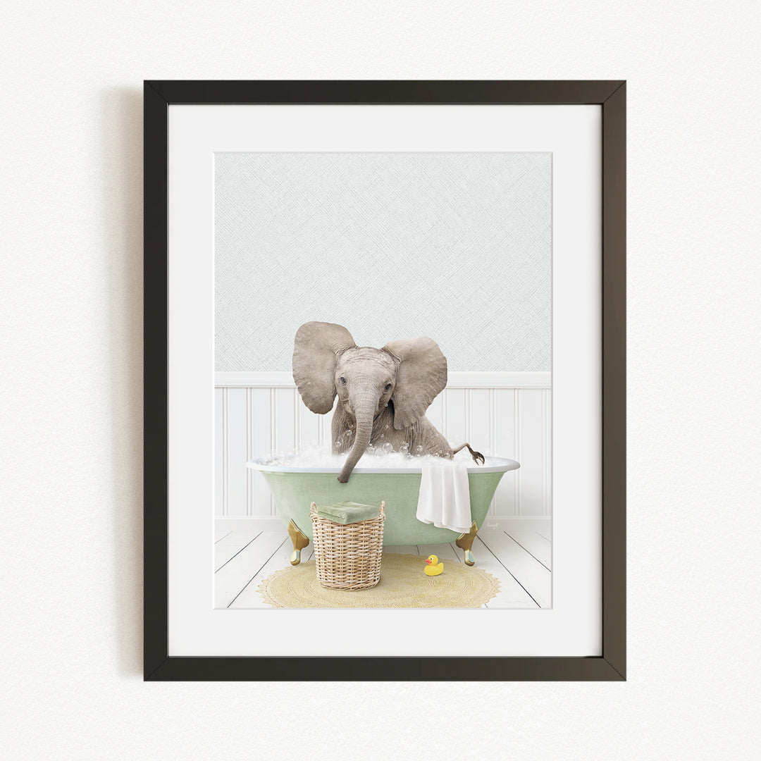 A gray elephant sitting in a green bathtub, surrounded by a basket of toys and a yellow rubber duck.