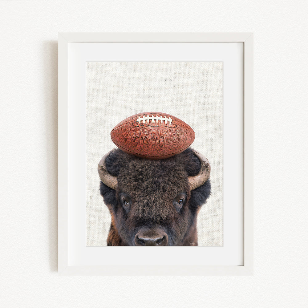 A buffalo with a football resting on its head.