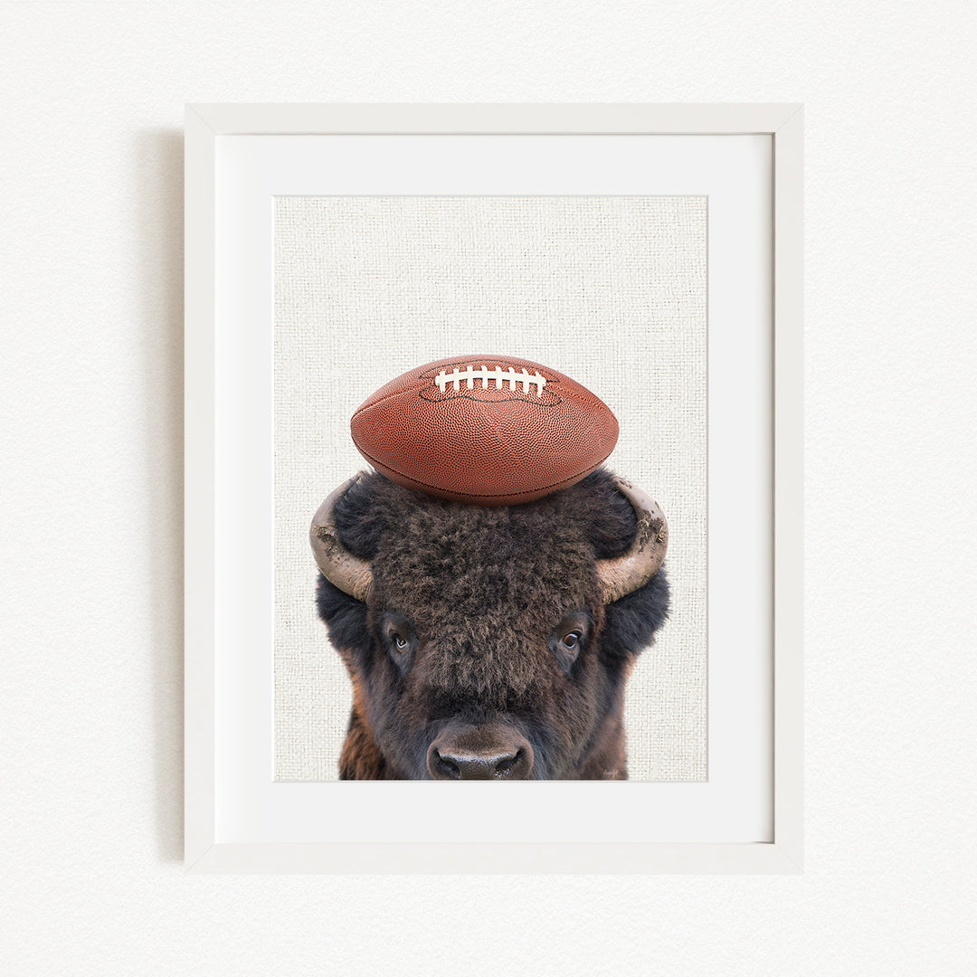 A buffalo with a football resting on its head.