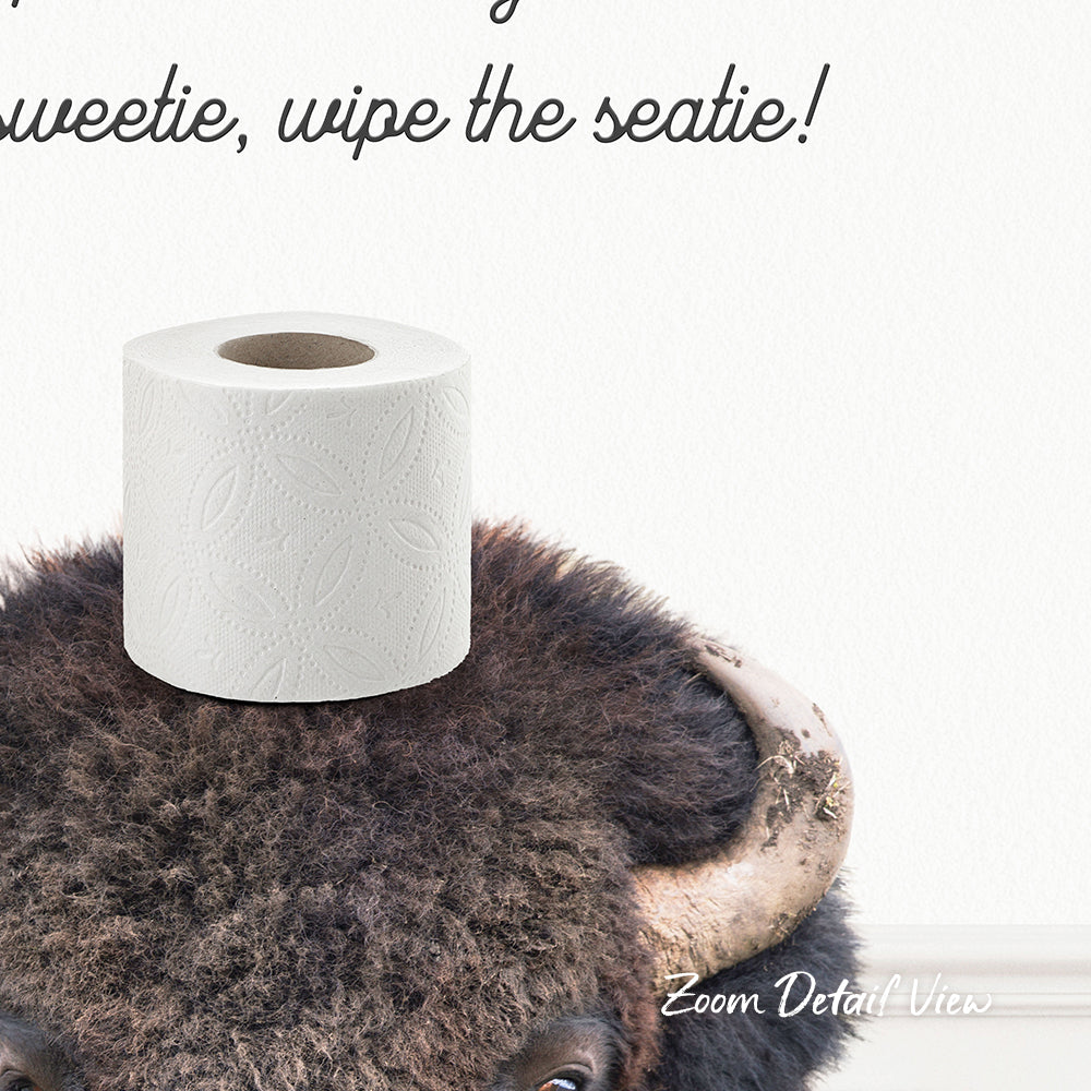 A roll of toilet paper placed on top of a bison's head, with the text "Sweetie, wipe the seatie!" written above it.
