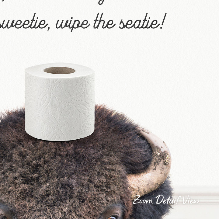 A roll of toilet paper placed on top of a bison's head, with the text "Sweetie, wipe the seatie!" written above it.