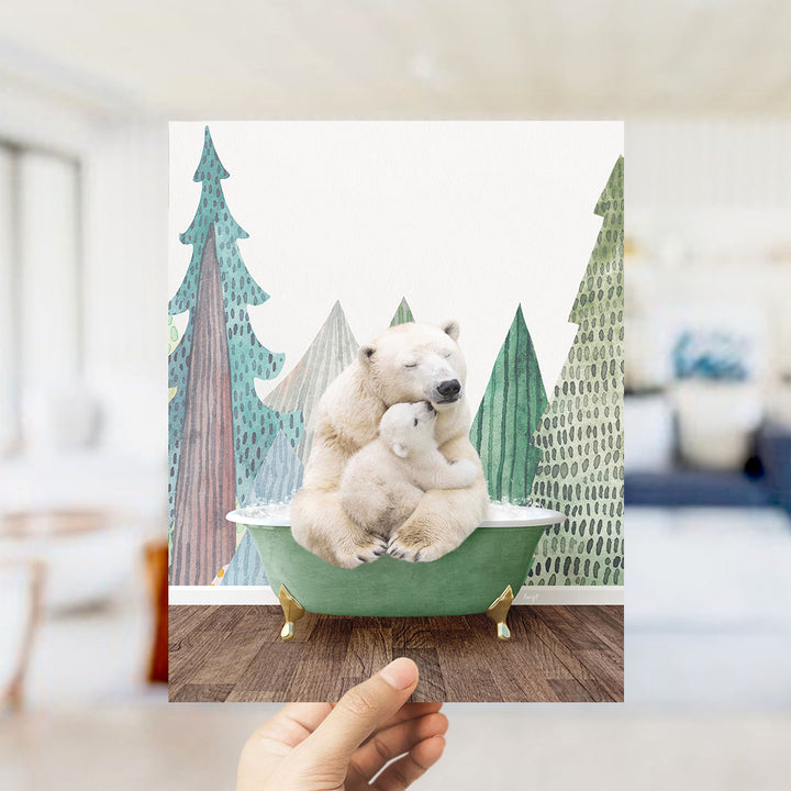 A hand holds up a framed image depicting a polar bear sitting in a bathtub, surrounded by a snowy landscape with trees and mountains in the background.