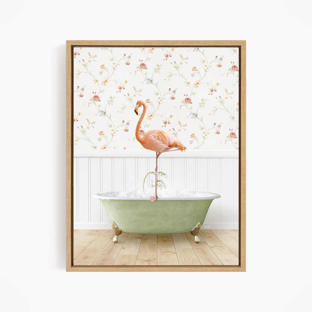 A pink flamingo stands on the edge of a green bathtub, with a floral wallpaper in the background.