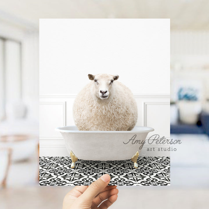 a hand holding a card with a sheep in a bathtub